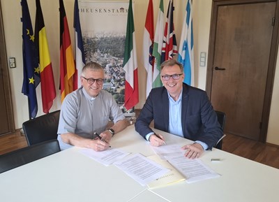 Pfarrer Martin Weber, Katholische Kirche Heusenstamm, und Bürgermeister Steffen Ball unterzeichnen die Erklärung zur nachhaltigen und städtebaulichen Entwicklung des Areals rund um die Pfarrkirche St. Cäcilia.