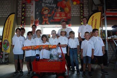 Die Mitglieder der Feuerdrachen im Jubiläumsshirt gemeinsam mit ihren Betreuern bei der Geschenkübergabe.