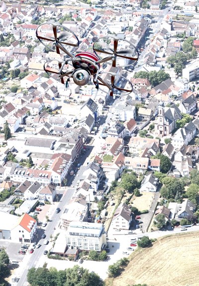 Fotomontage: Eine Drohne fliegt über das Stadtgebiet.