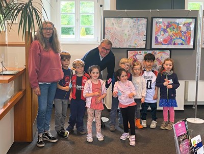 Bürgermeister Steffen Ball (Mitte) eröffnet die Kinderhaus-Ausstellung ganz offiziell. Susanne Lehnen (l.) und die Kinder freuen sich riesig.