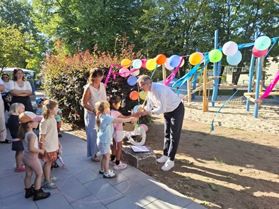 Kerstin Wunderlich und Bürgermeister Ball eröffnen das Außengelände gemeinsam mit den Kindern.