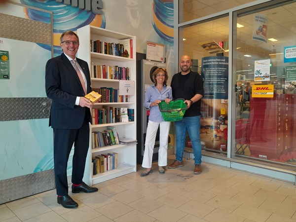 Die neue „Außenstelle“ des öffentlichen Bücherschranks wird gut angenommen. V.l.: Bürgermeister Steffen Ball, Stadtbüchereileiterin Katja Richter, Marktleiter Sedat Tekin.