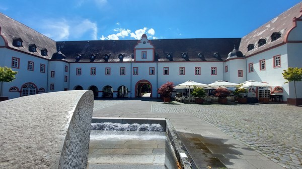 Schloss-Innenhof mit Außengastronomie.