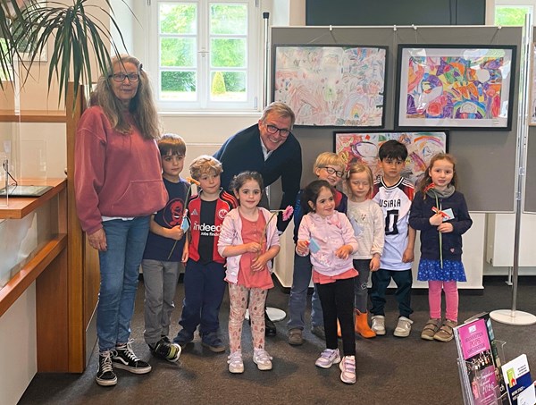 Bürgermeister Steffen Ball (Mitte) eröffnet die Kinderhaus-Ausstellung ganz offiziell. Susanne Lehnen (l.) und die Kinder freuen sich riesig.