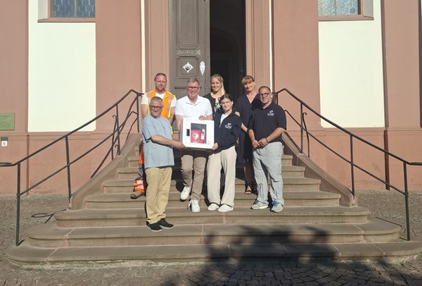 Bei der Übergabe des neuen Defibrillators in St. Cäcilia. V.l. erste Reihe: Pfarrer Martin Weber, Bürgermeister Steffen Ball, Greta Mereu und Sebastian Bergold (Voraushelfer-System/Team ERD), v.l. hintere Reihe: Nikolas Lütz (Bauhof-Team), Ninja Weis (Ambulante Intensivschwester) und Beate Schütz (Projektmanagement) der Asklepios Klinik Langen.