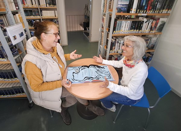 Cornelia Löwenberg vom Fachdienst Kultur, Sport & Ehrenamt (l.) und Büchereileiterin Katja Richter (r.) demonstrieren das Hooked on a Book-Projekt.